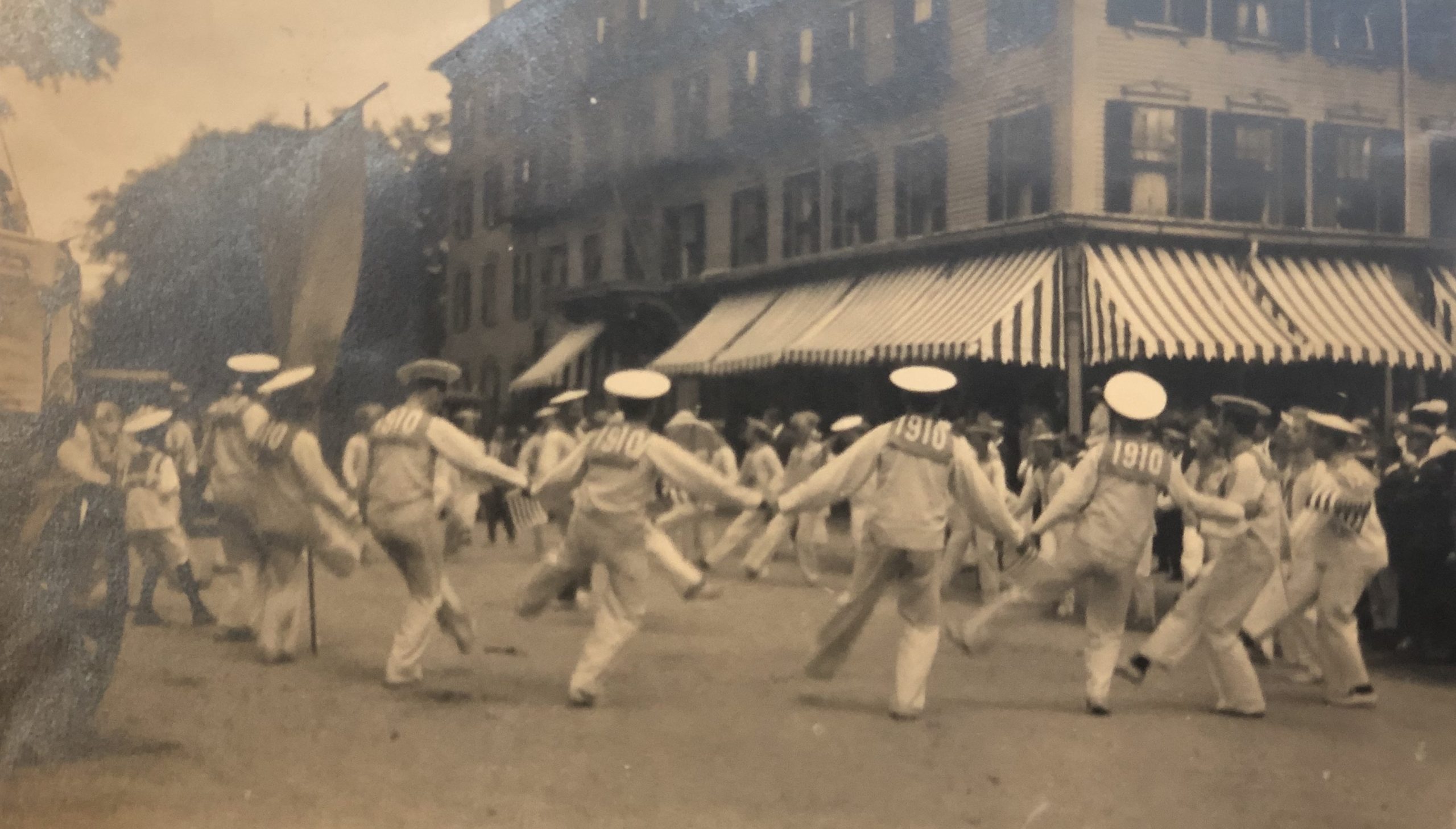 12 - e kendall gillett scrapbook 15 A black and white photograph in an album shows men from the class of 1910 dressed as sailors with dancing in the street at their three-year reunion.