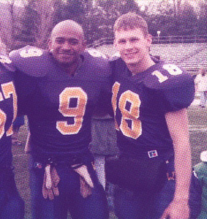 Two male students pose together in their football uniforms.