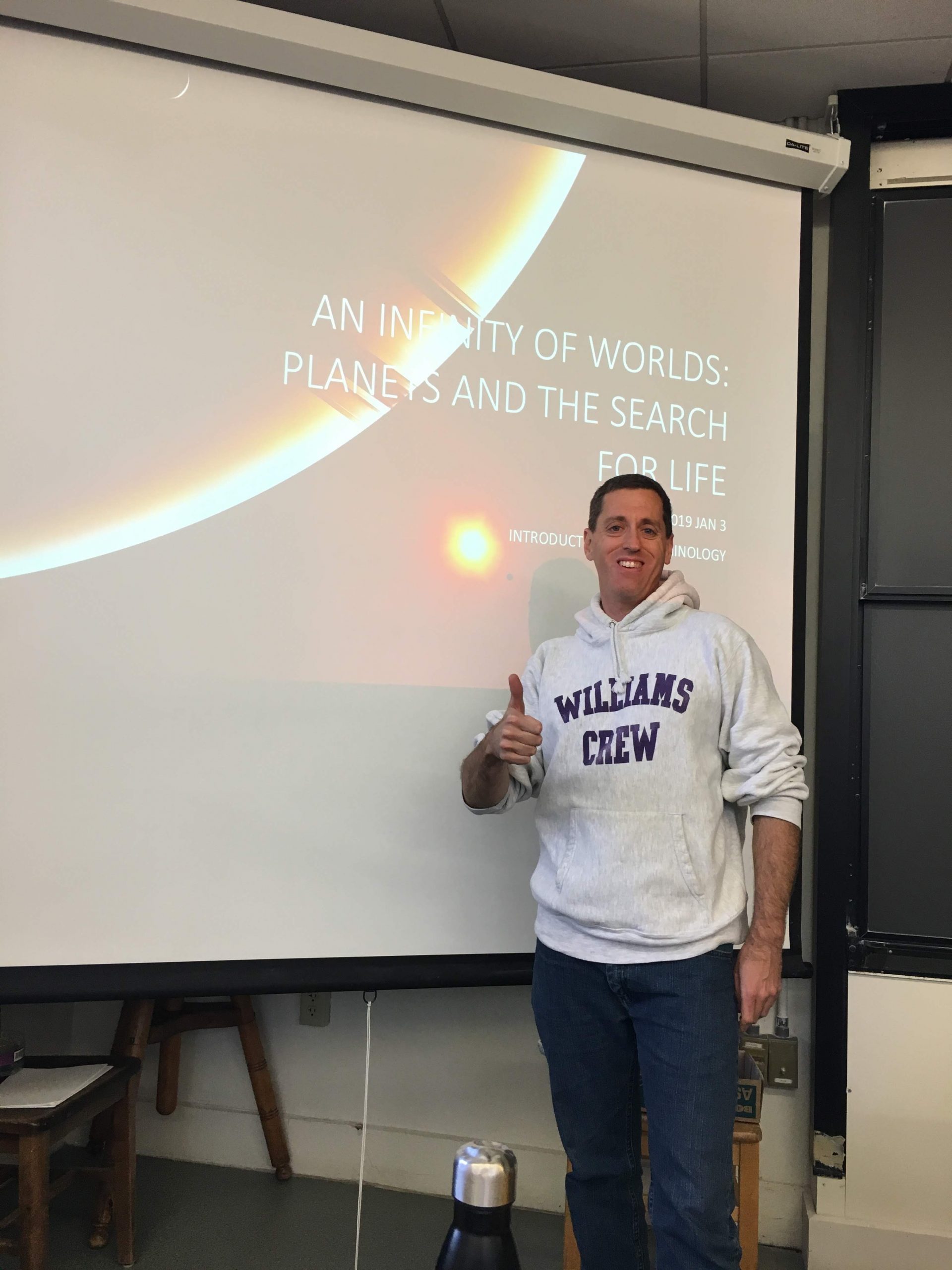 Person standing with Thumbs Up in front of Lecture Screen