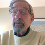 man wearing glasses and yellow sweater