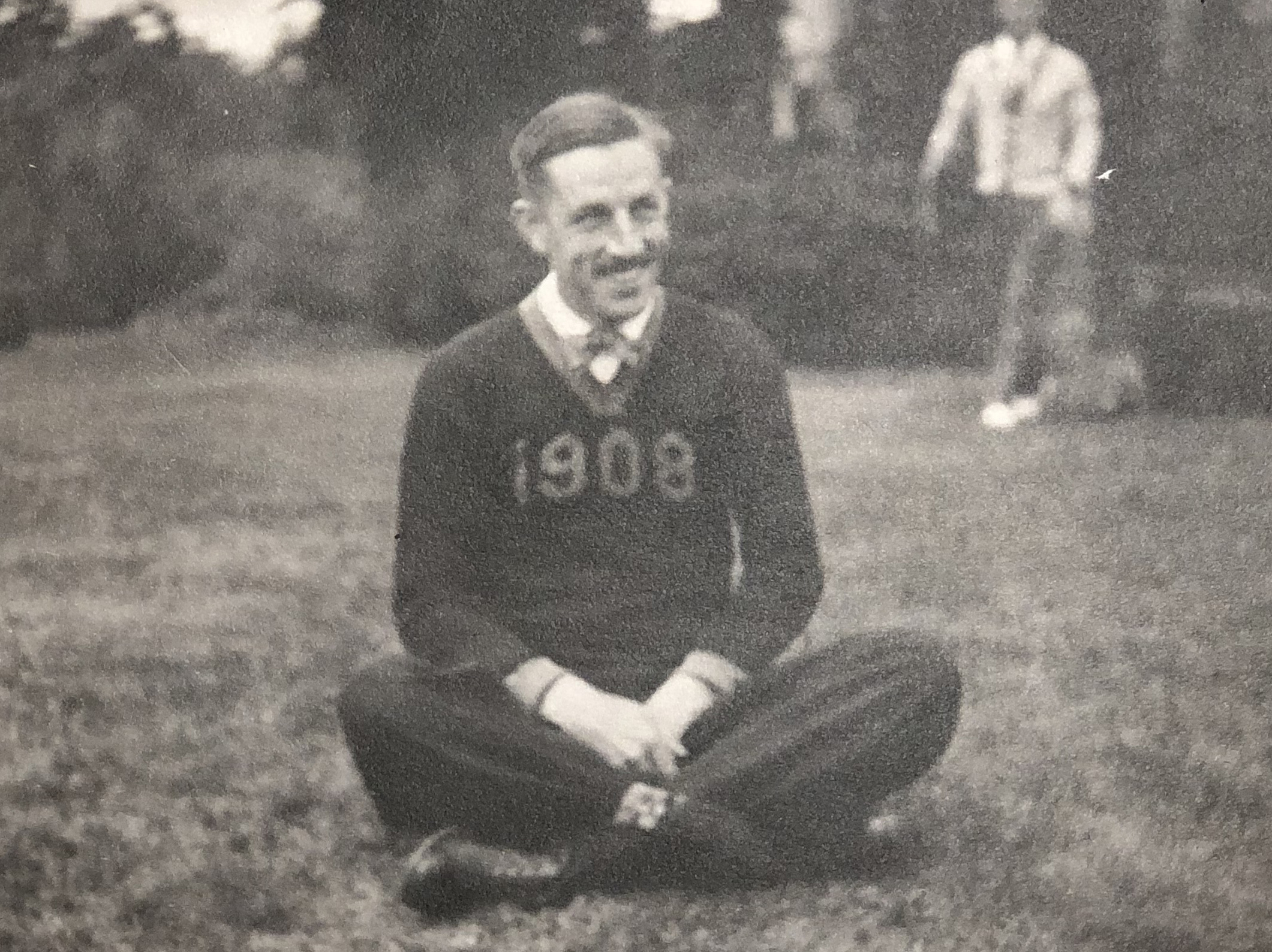 An archival black-and-white photography of E. Kendall Gillet, who wears a sweater with the year 1908 across the chest.