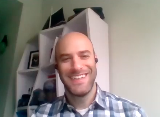 of man sitting down and smiling.
