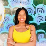 a person wearing a yellow top with long braided hair and a background with abstract circular green and aqua blue patterns