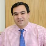 a photo of a person wearing a light pink shirt with blue tie