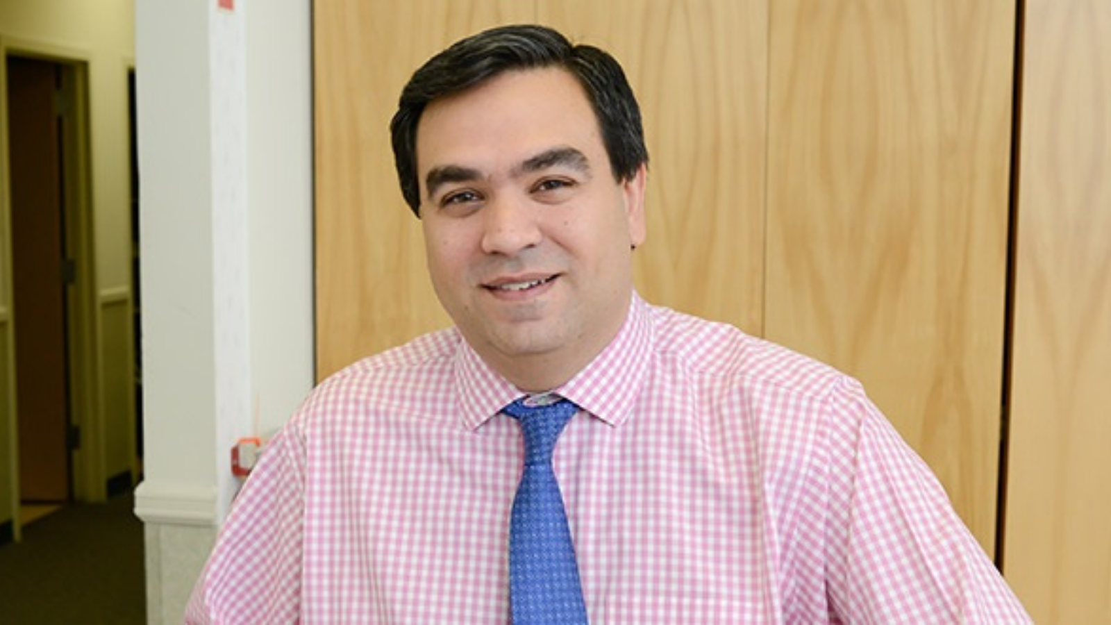 a photo of a person wearing a light pink shirt with blue tie