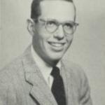 Black and White headshot of a man in glasses and a suit and tie