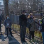 People who are eligible and registered wait in line to get COVID-19 vaccine at NYC Health Department Vaccine Hub at Hillcrest High School in Queens.