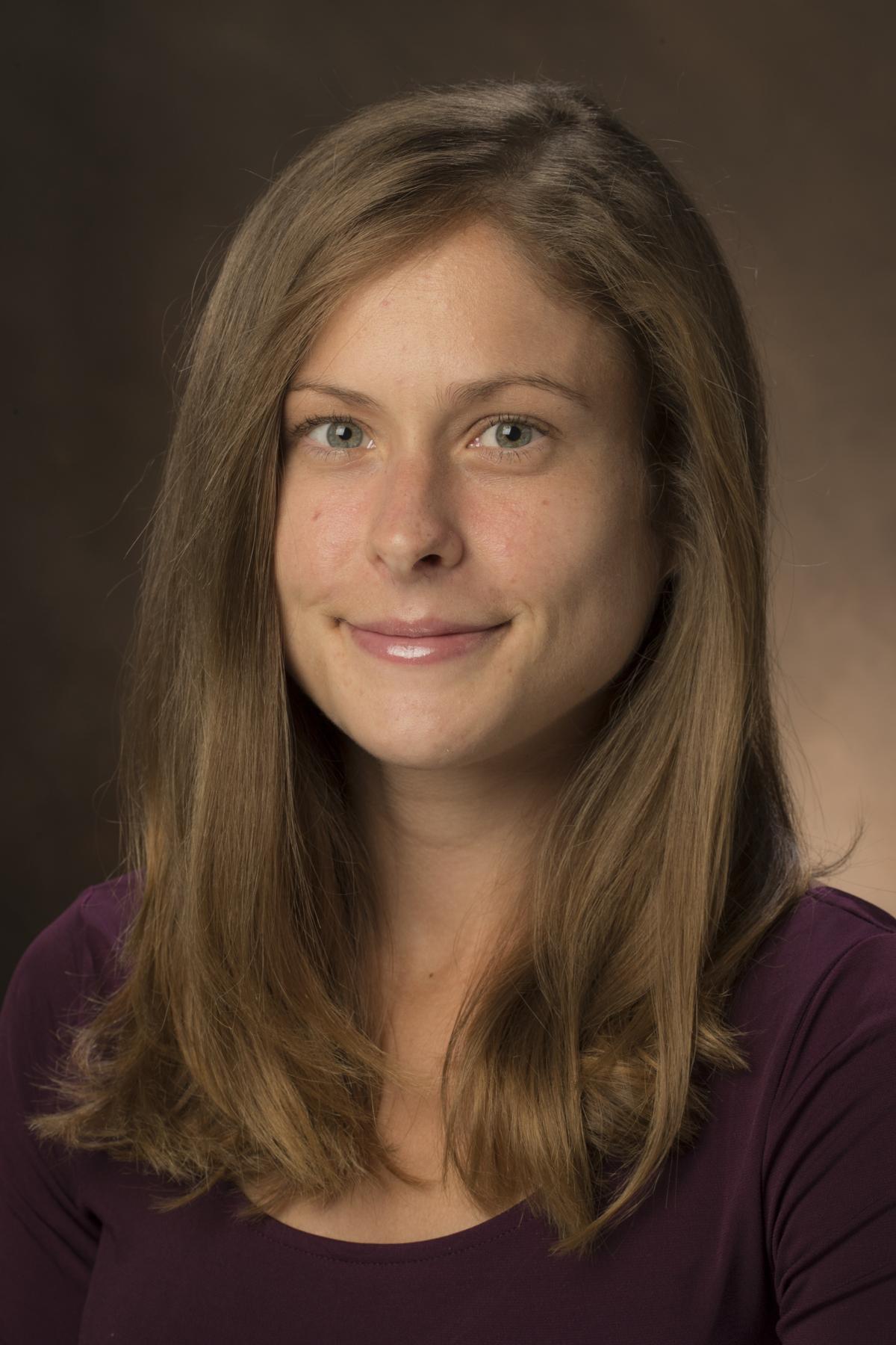 a portrait photo of a person wearing a dark top, with long blonde hair