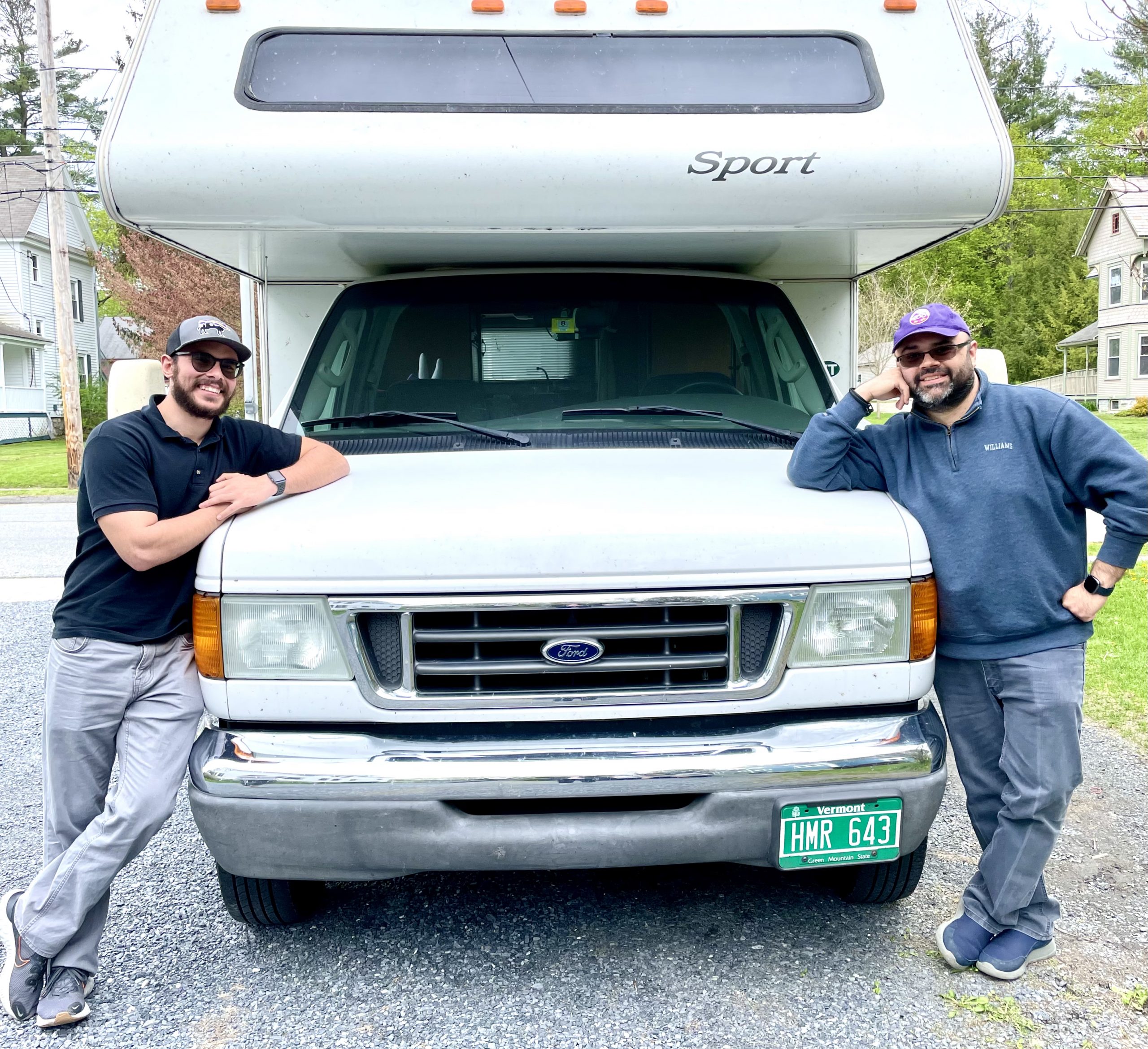 photo of 2 people posing in front of an RV