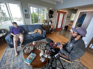 2 people sitting down for an interview inside a living room