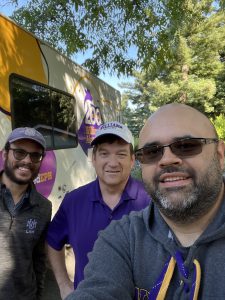 3 people posing for a selfie in front o fan RV with pink and yellow spots