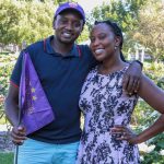 2 people posting or a photo while one holds a purple flag.