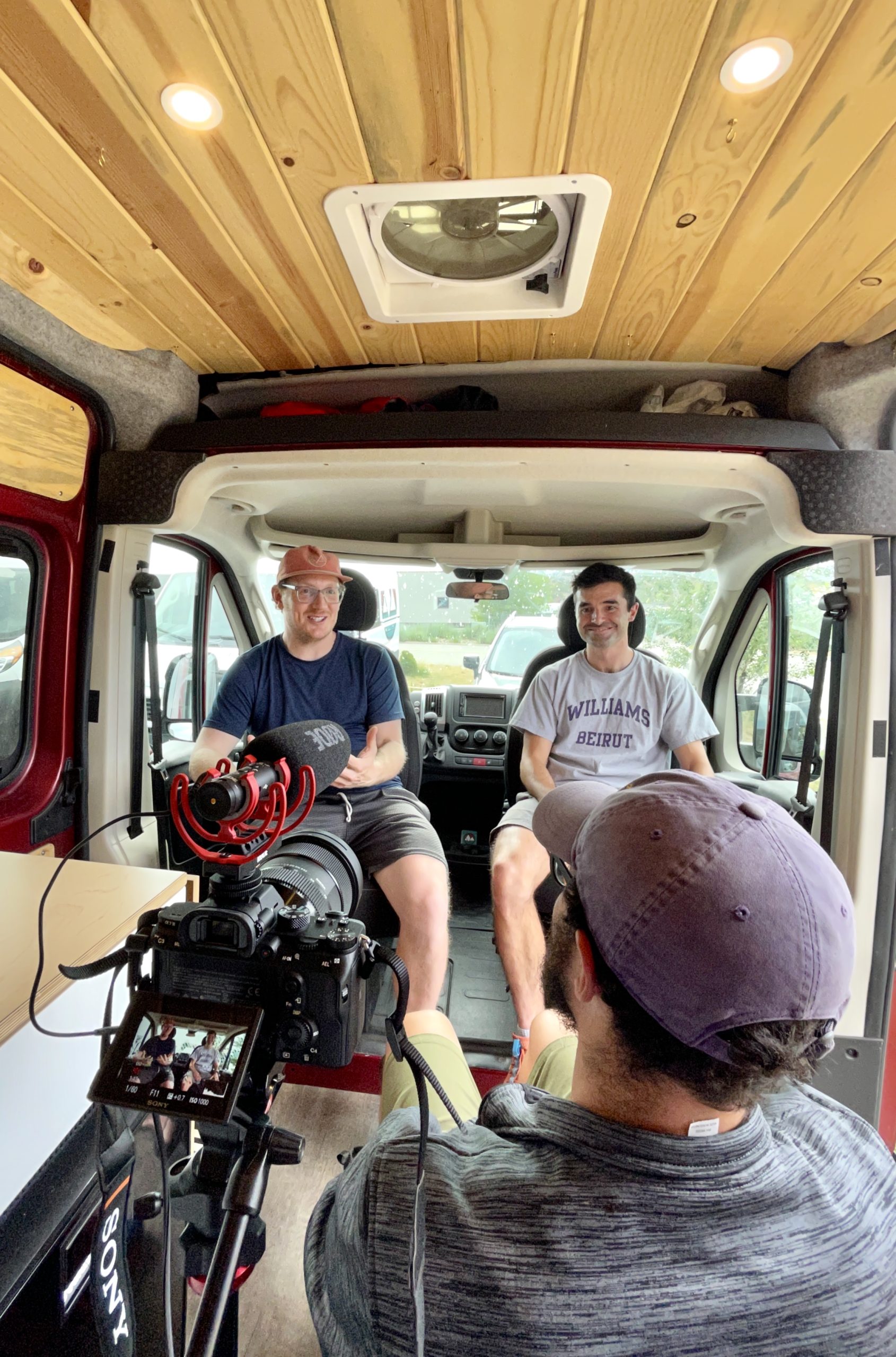 3 people in an on-camera interview inside a van